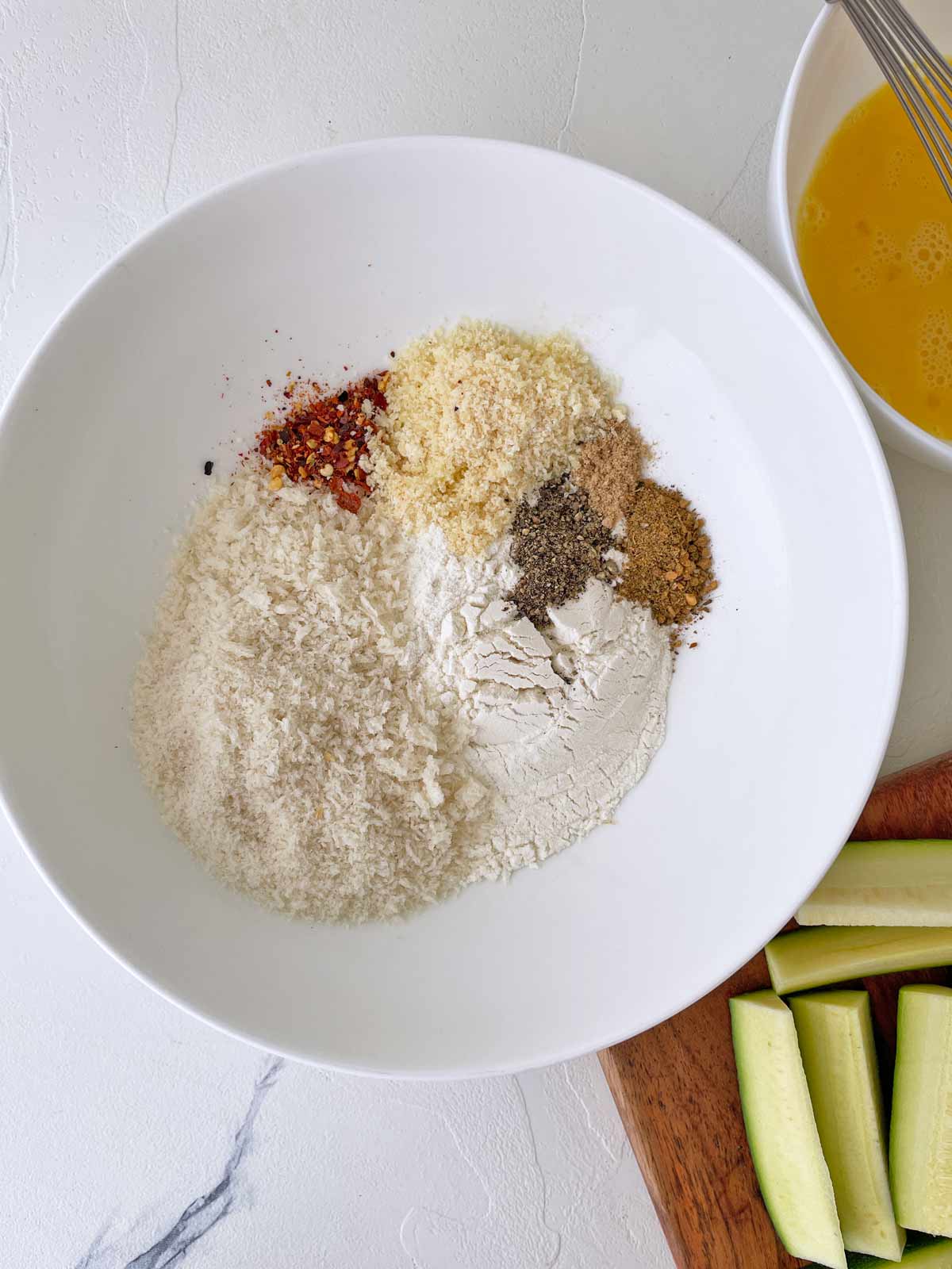 Small bowl with beaten egg and a larger bowl with all the dry ingredients for the breading.