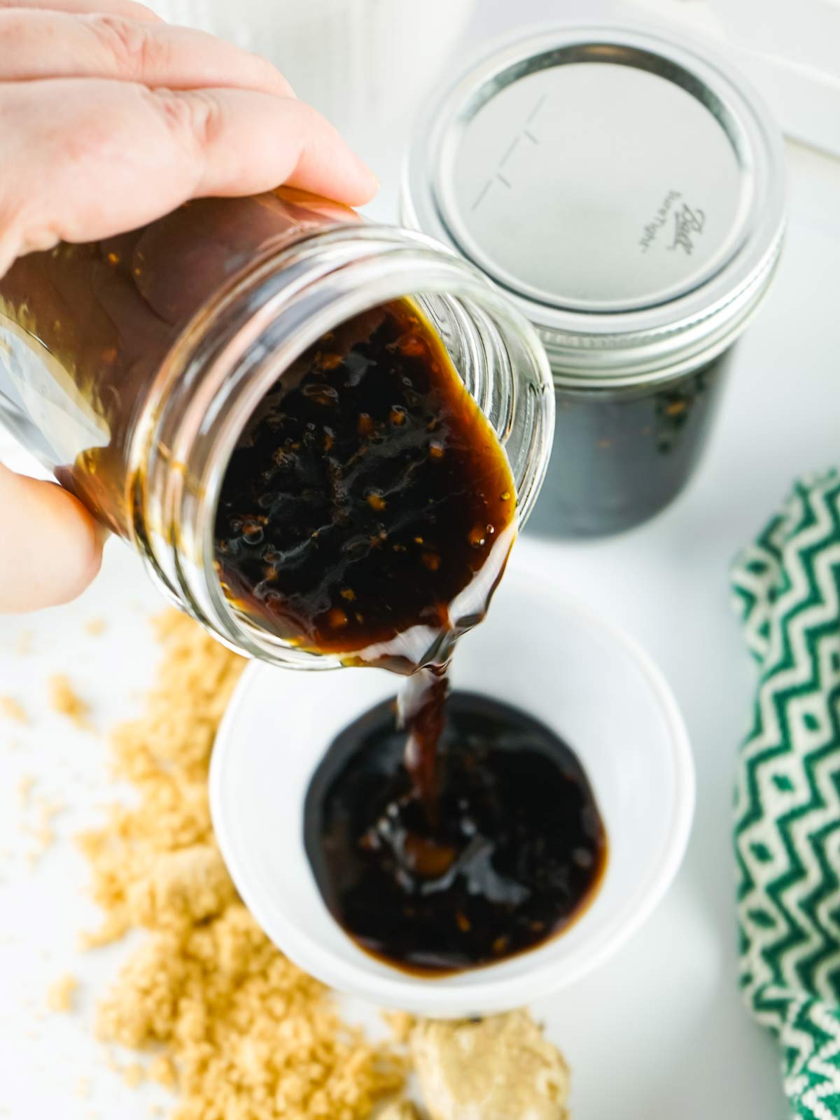 Pouring the teriyaki sauce into a small jar.