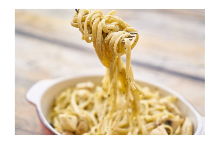 A fork is being used to pick up a bowl of pasta.