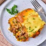 A plate of shepherd's pie on a table with a fork.