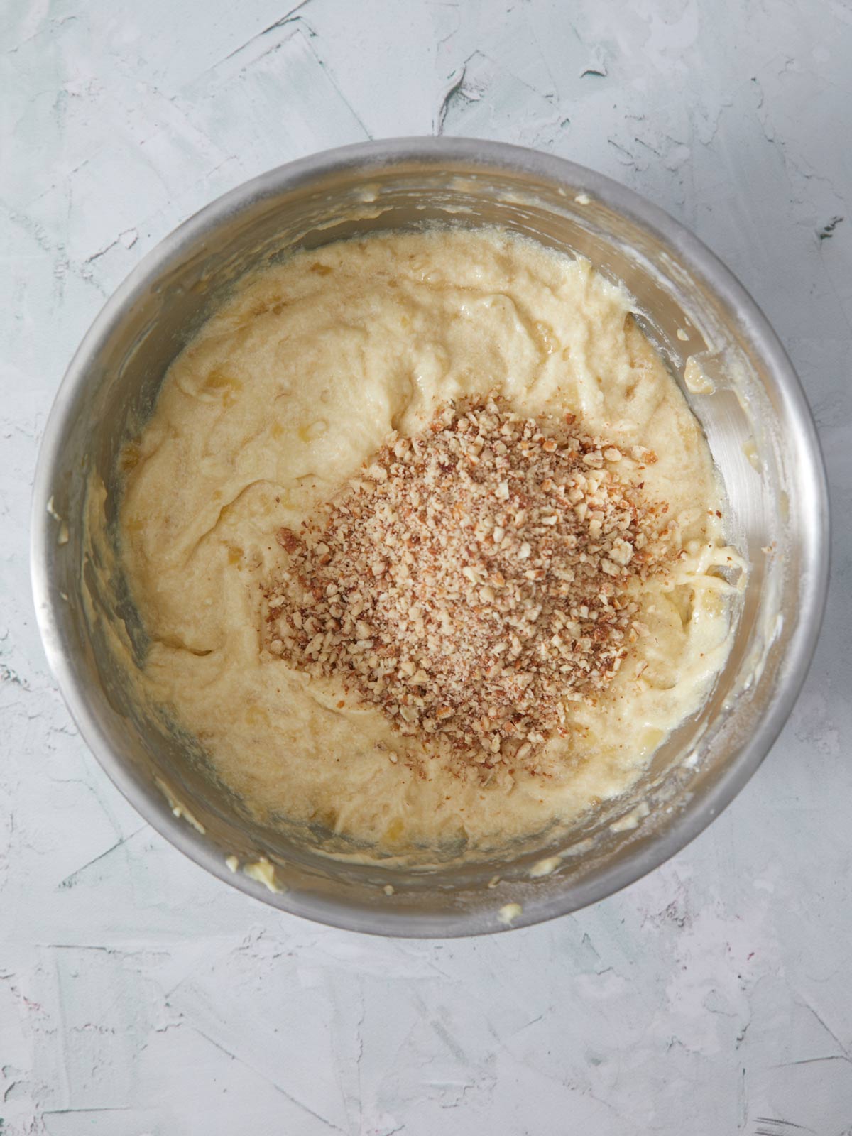 Cake batter with finely chopped pecans poured in.