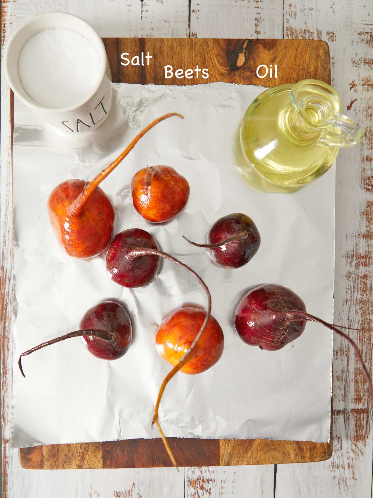 Beets, salt, and oil oil on a cutting board.