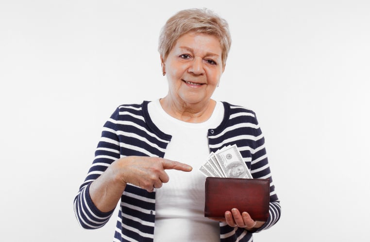 A woman holding a wallet with money in it.