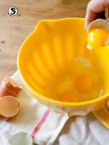 Eggs being added to mixing bowl.