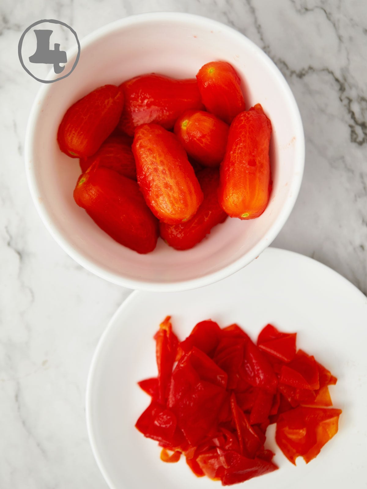 Bowl of peeled tomatoes alongside a plate of the peels.