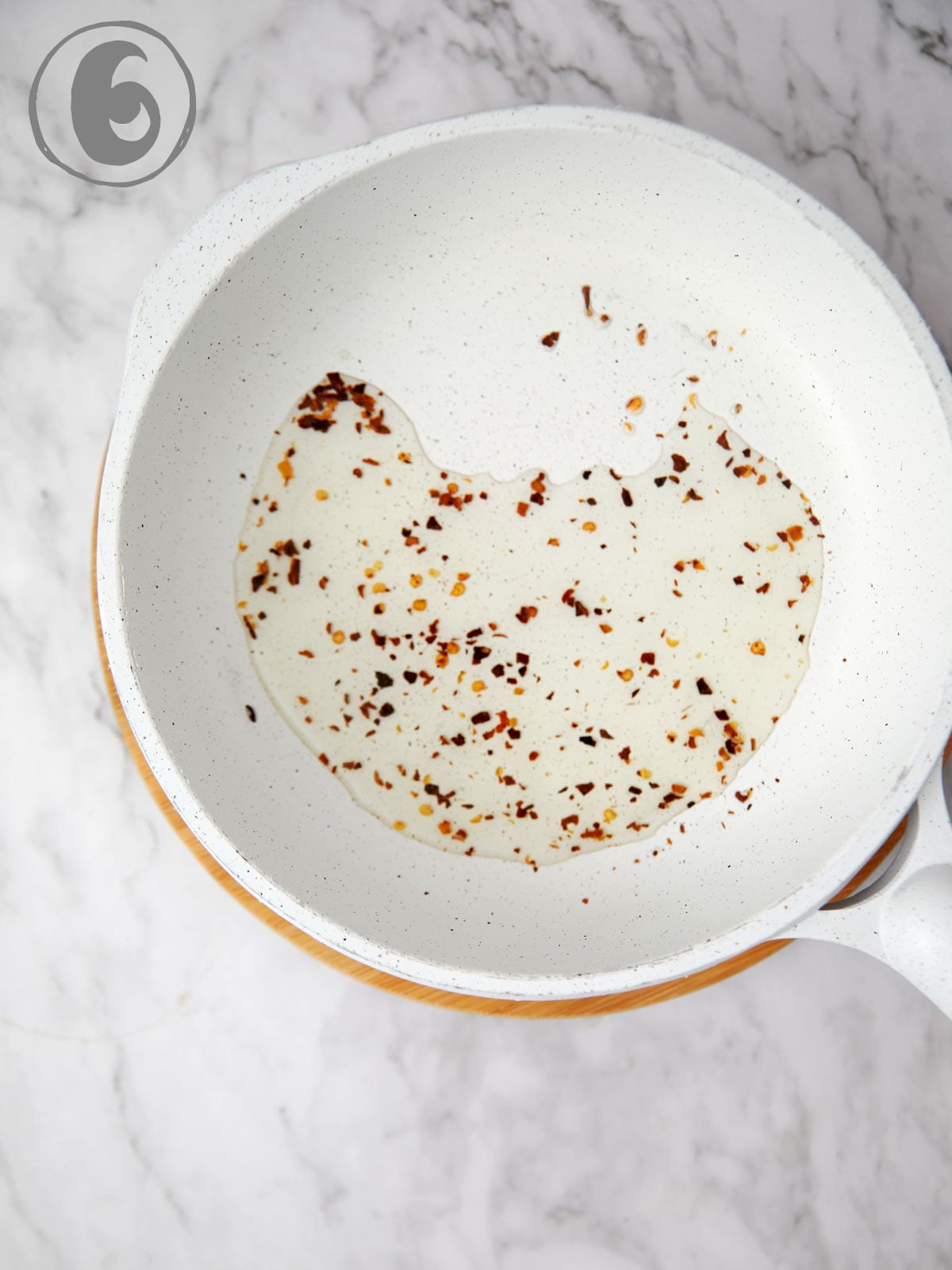 Saute pan with oil and red pepper flakes.