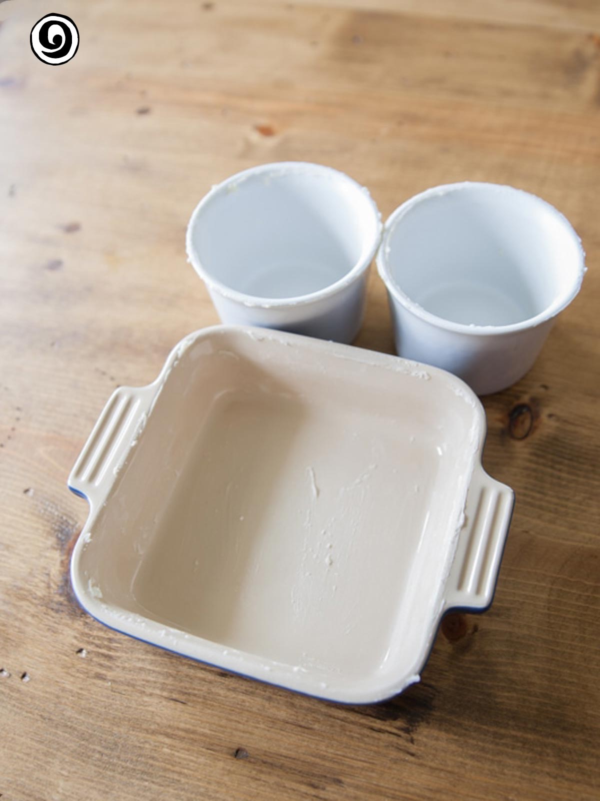 Greased baking pan and two gread ramekins.