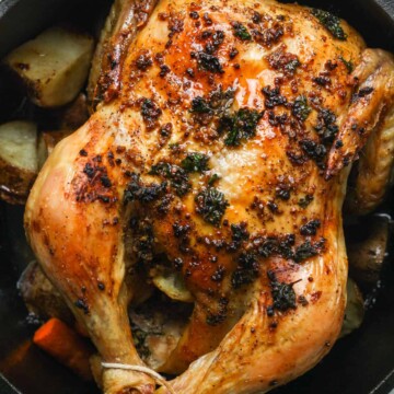 A roasted chicken in a cast iron skillet.