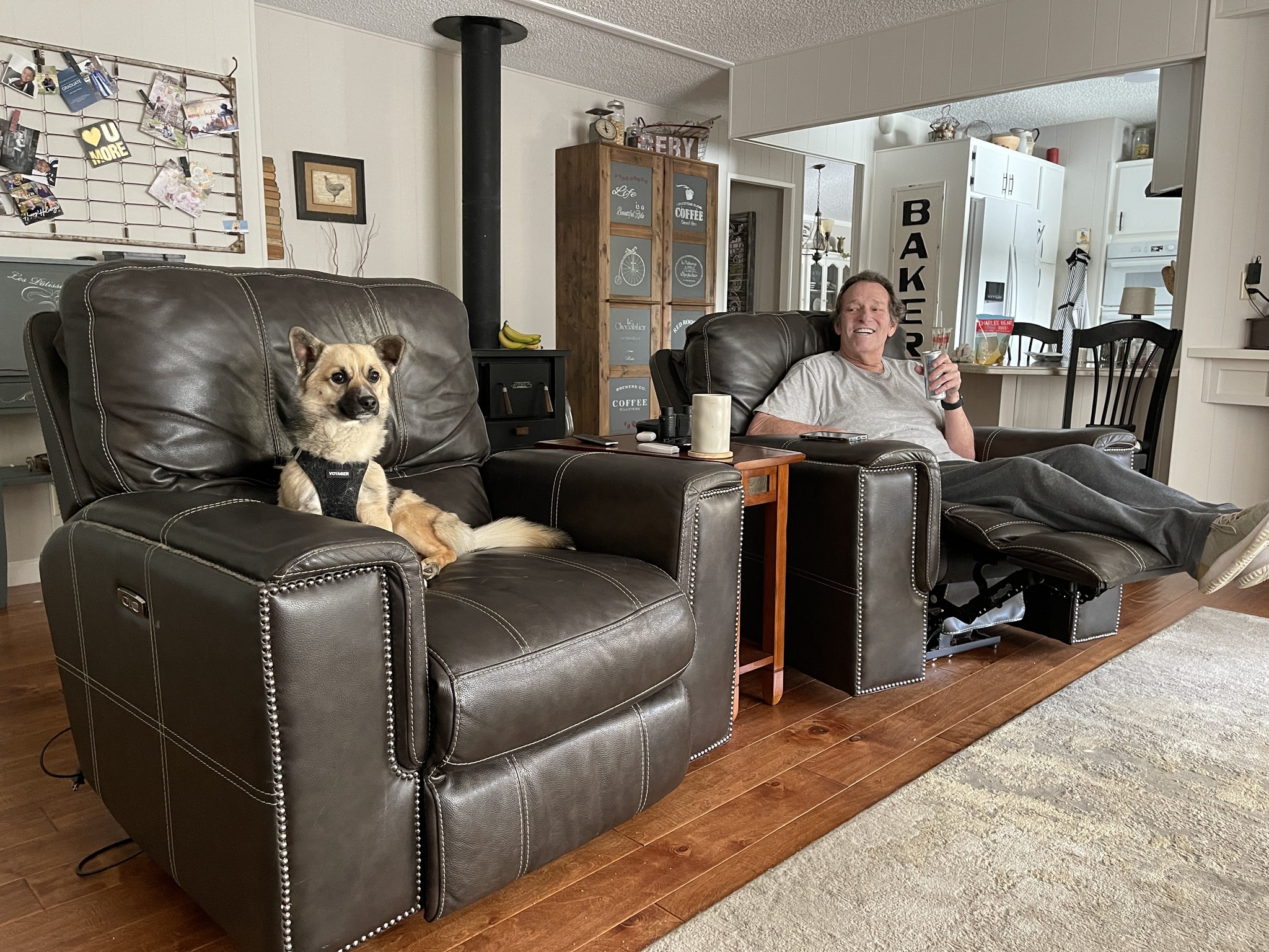 A man sits in a recliner with his dog.