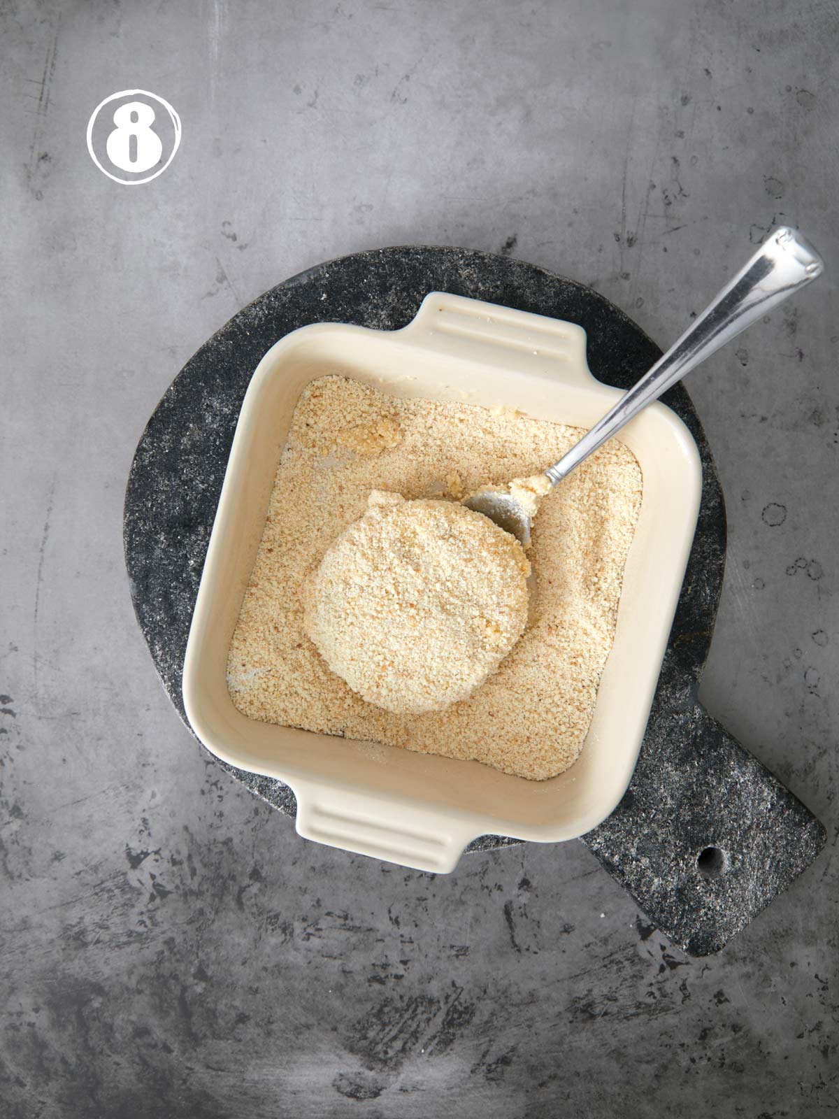 A bowl of powder with a spoon in it.