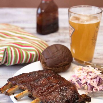Bbq ribs with coleslaw and beer on a plate.