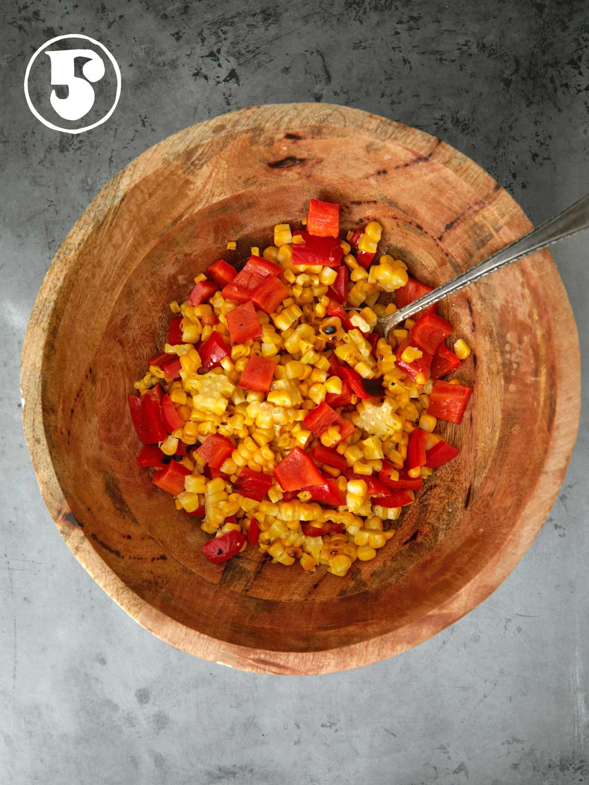 Corn and peppers in a wooden bowl.