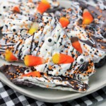 A plate of halloween candy bark covered in sprinkles and candy canes.