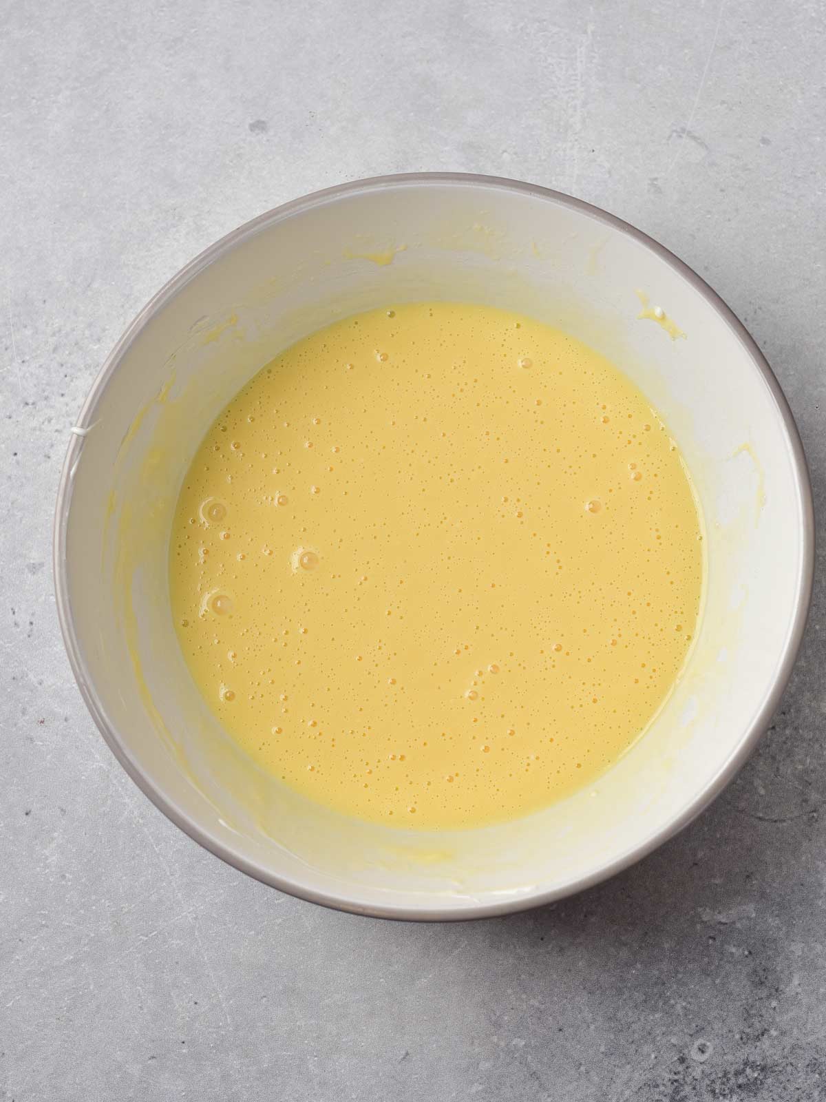 A bowl with wet ingredients in it.