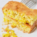 A piece of cornbread on a white plate.