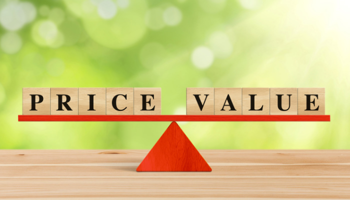 The word price value on a wooden scale on a green background.