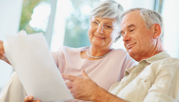 An older couple looking at a piece of paper.