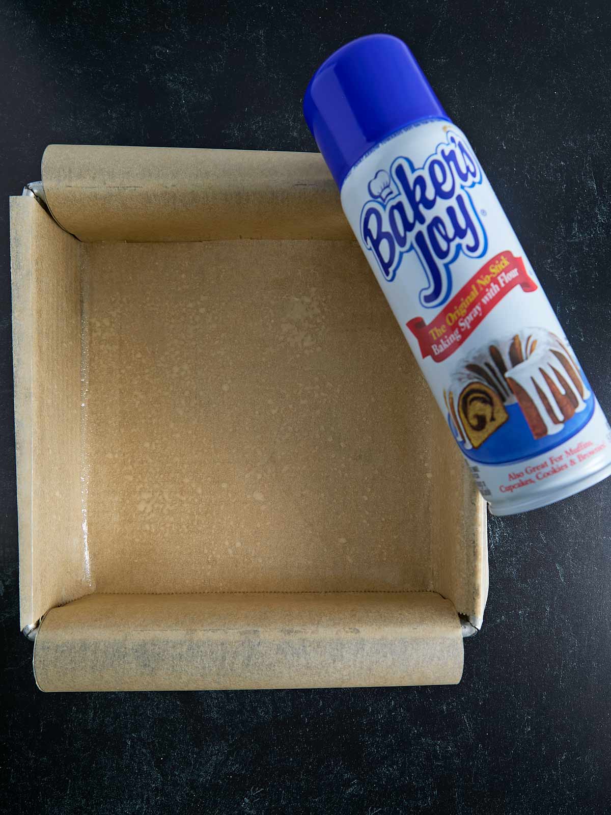 Parchment paper lined baking pan with image of baking spray.