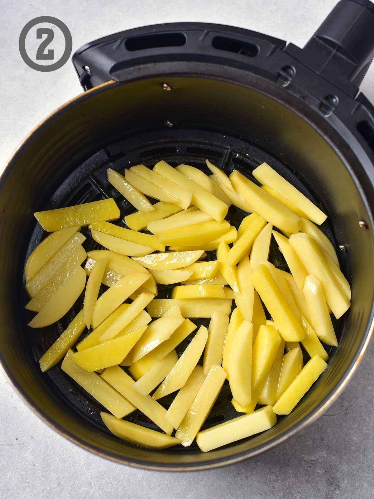 A bowl of french fries in an air fryer.