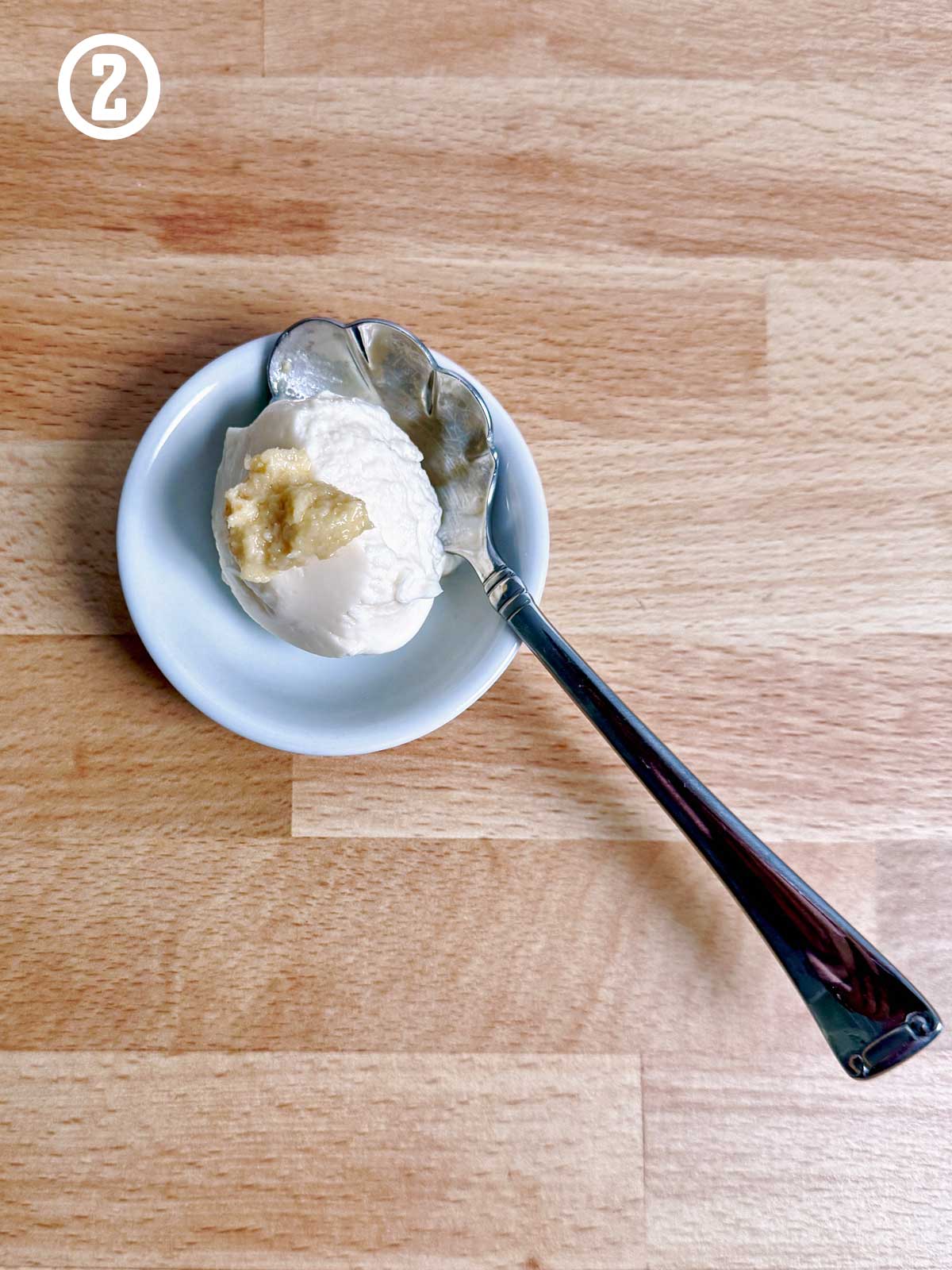 A spoon with a scoop of mayonnaise and horseradish on it.