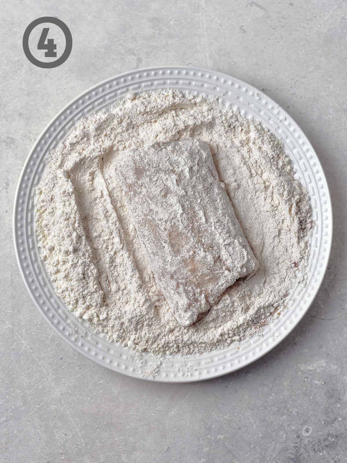 A plate of flour with a piece of fish.