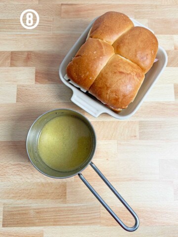 A pan with a loaf of bread next to a bowl of sauce.