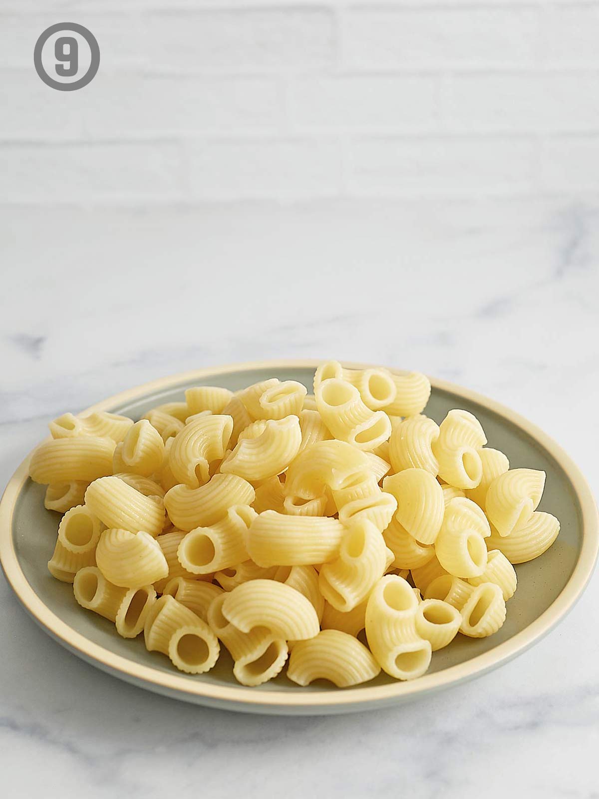 A plate of pasta on a marble table.