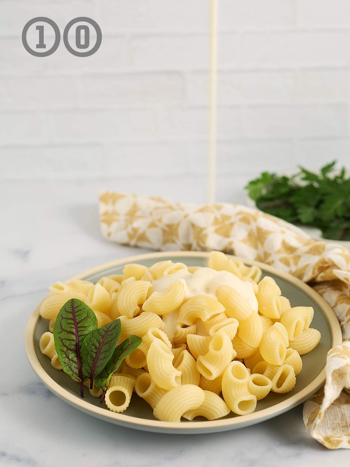 A plate of pasta with a garlic Parmesan sauce being poured over it.