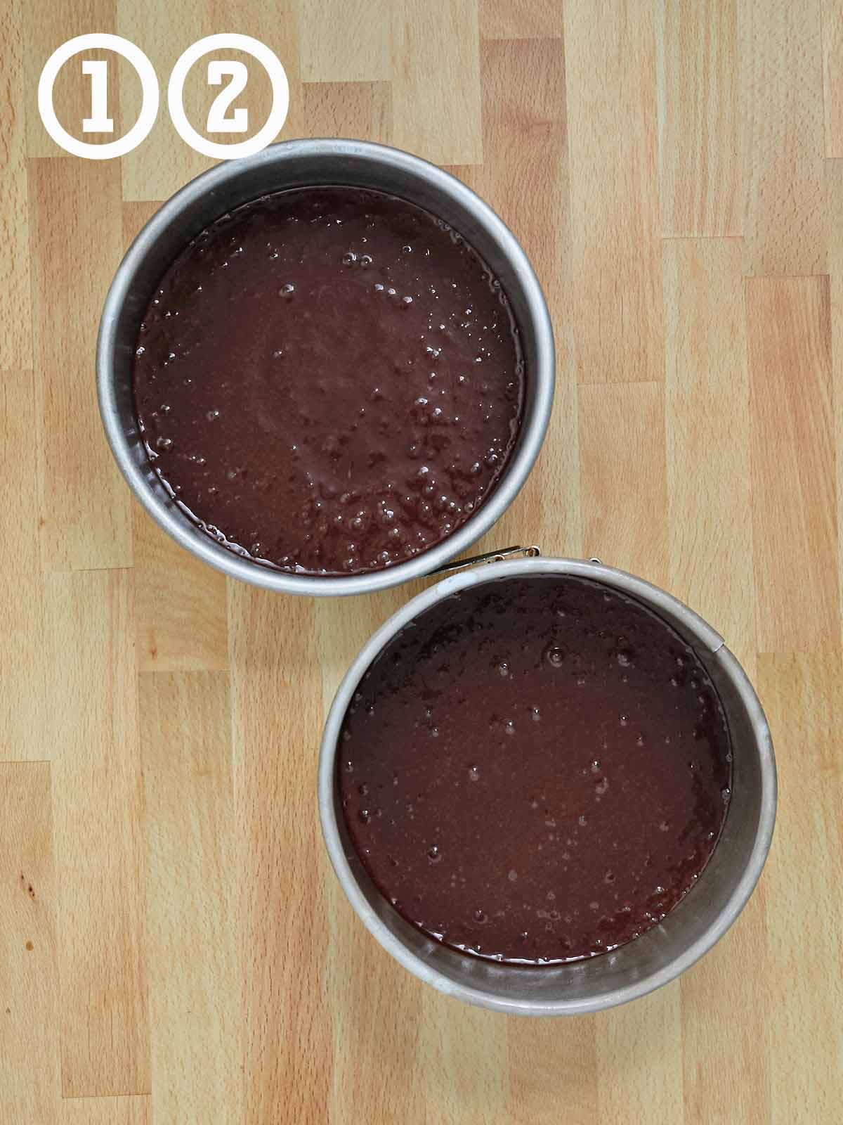 Two bowls of chocolate batter sit on a wooden table, ready to be transformed into a delicious Guinness chocolate cake with Irish buttercream.