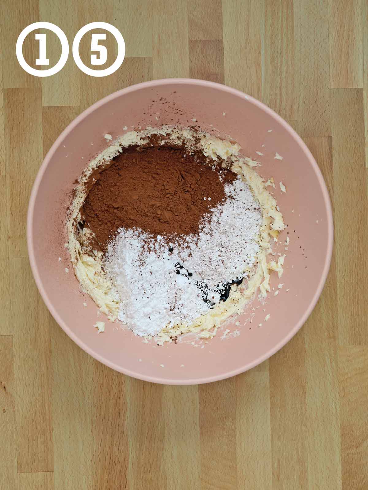 A pink bowl with a mixture of cocoa powder and powdered sugar for making chocolate Guinness cake.