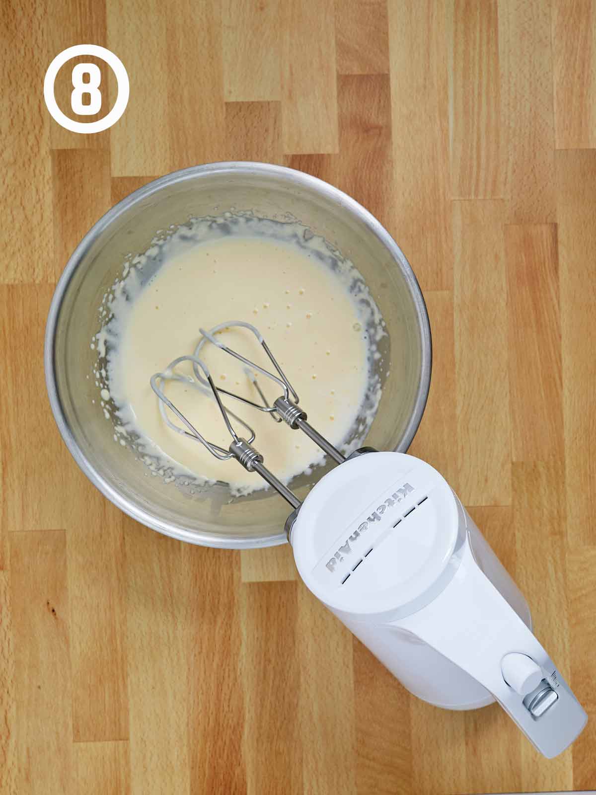 A mixing bowl topped with a whisk, for preparing a decadent Guinness chocolate.
