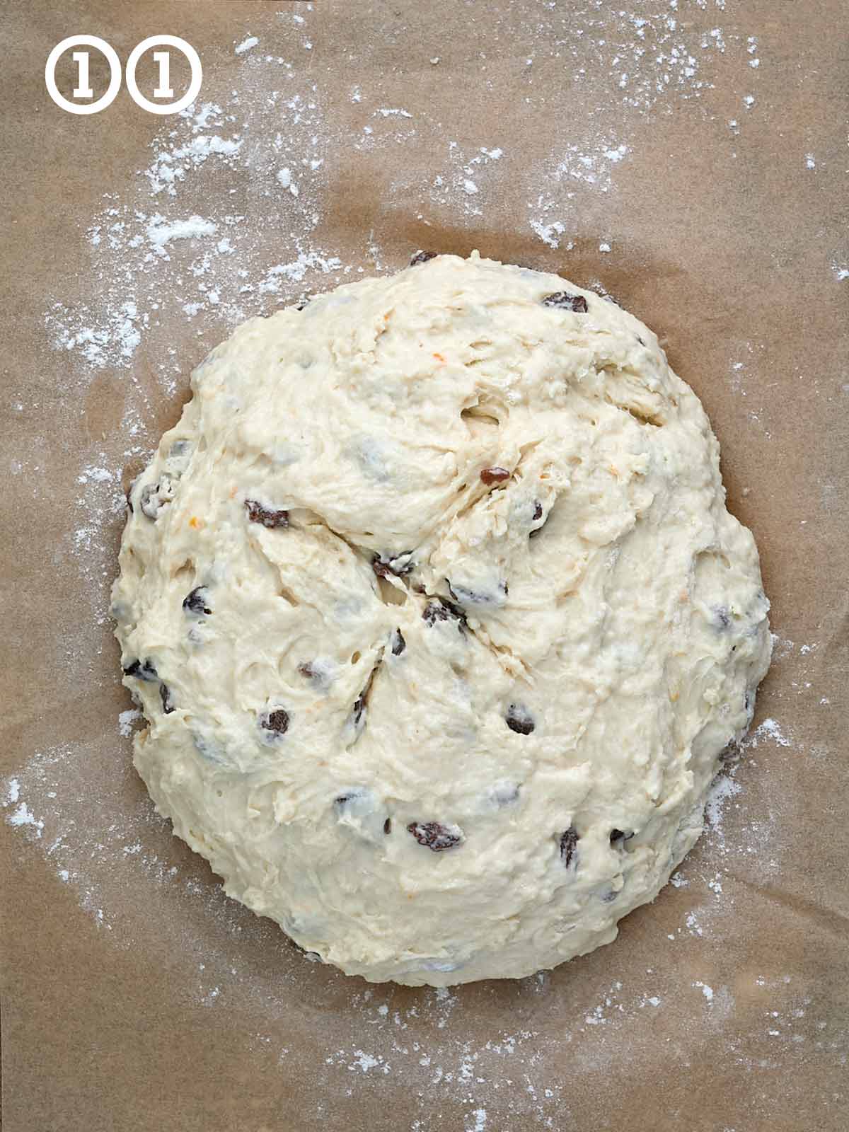 A dough is sitting on a piece of parchment paper.