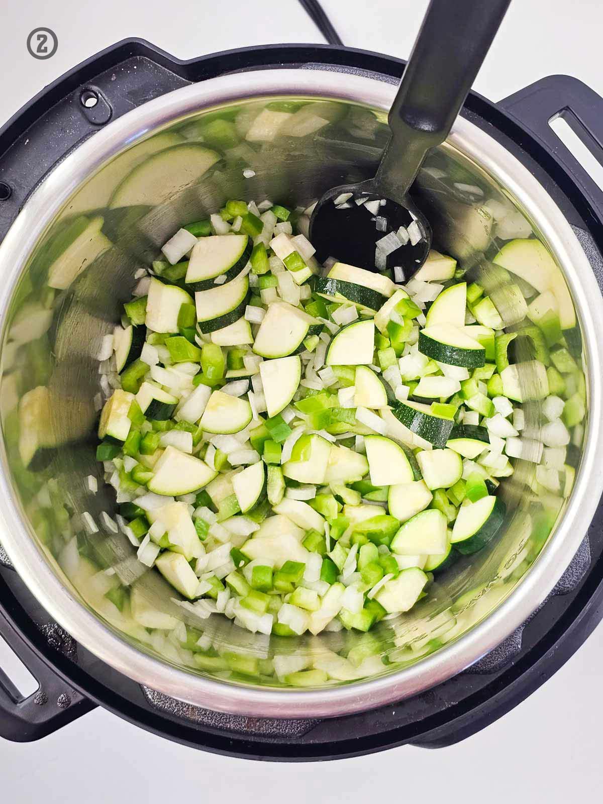 An instant pot filled with zucchini and onions, ready to be turned into a flavorful Mexican Vegetable Soup.