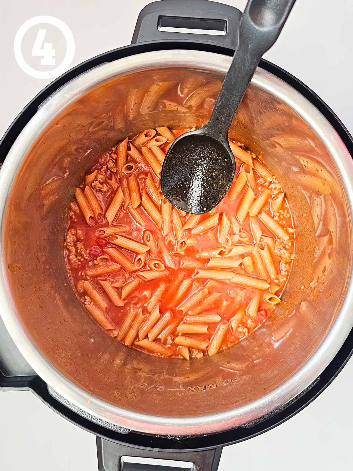 A pot of pasta with a spoon.