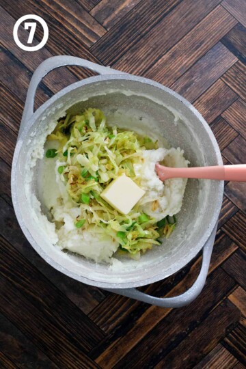 A bowl of Irish colcannon potatoes and cabbage with a spoon.