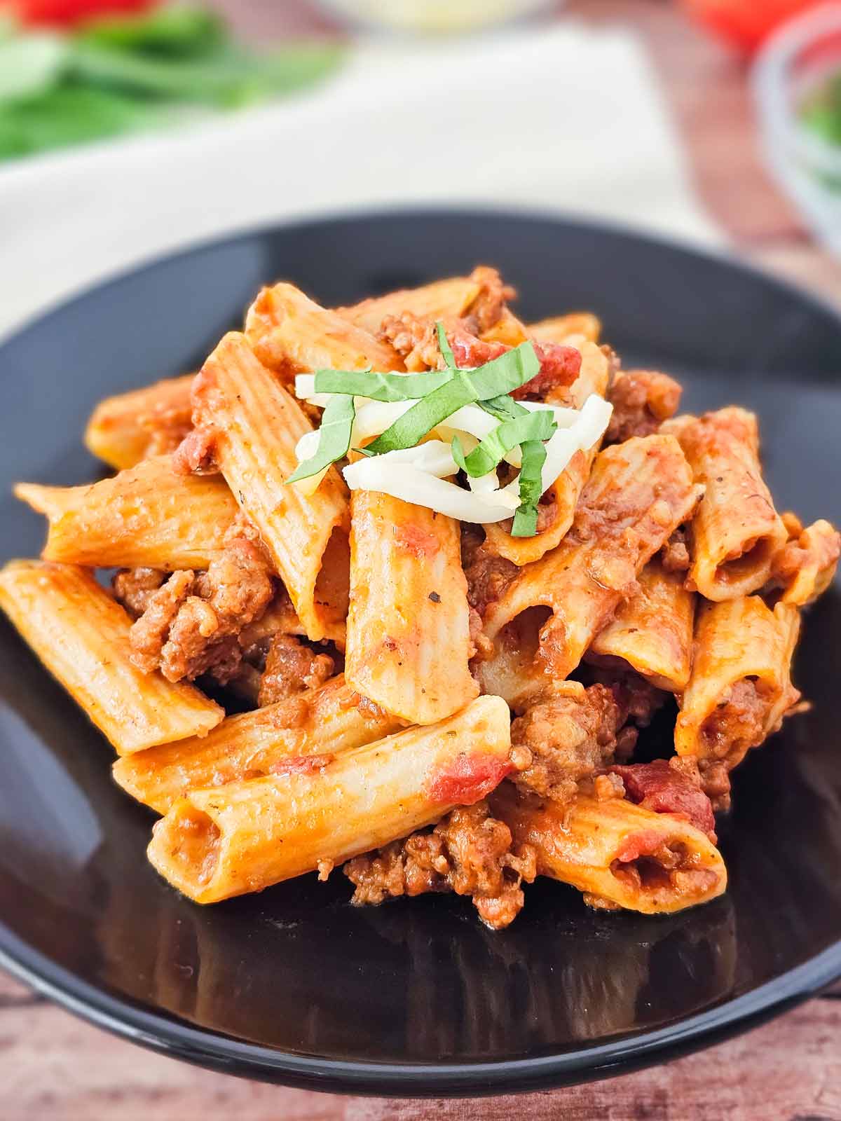 A plate of pasta with meat and cheese.