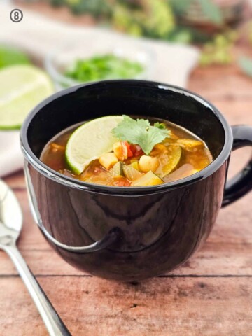 A bowl of Mexican Vegetable Soup with a lime wedge on top.