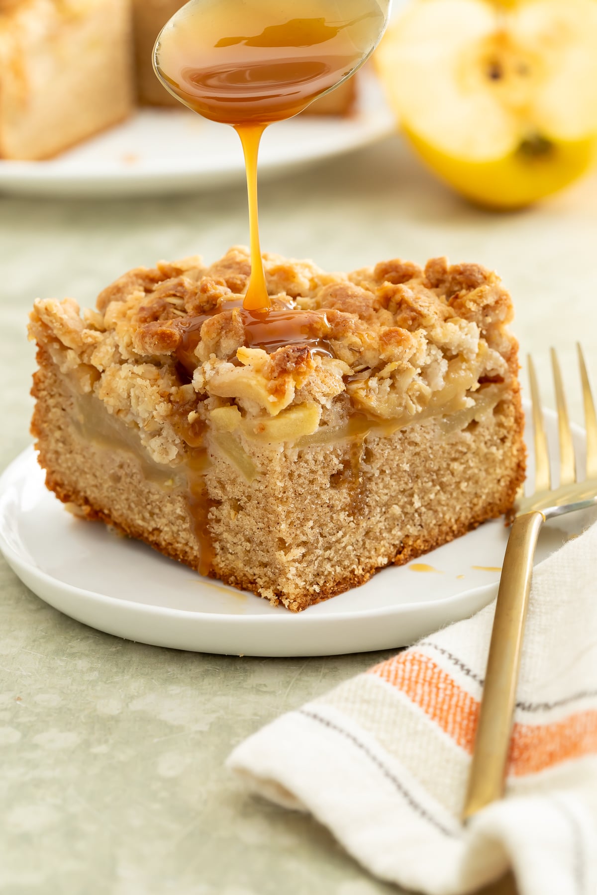 A piece of cake with caramel sauce being poured onto it.